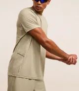 Remera deportiva gris con cuello redondo, mangas cortas, estampa heat print y detalle en los hombros. Confeccionada en tejido de malla con tecnología Dry.