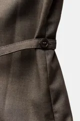Camisa marrón de Zara Woman Collection confeccionada en hilatura con viscosa, de cuello solapa y manga larga acabada en puño. Presenta un bolsillo de plastrón en el pecho, cinturón en mismo tejido ajustable con lazadas y bajo asimétrico.