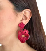Aros colgantes con forma de flor hechos en resina color fucsia. Se ajustan con perforación y no contienen níquel.