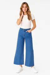 Pantalón de jean color gris oscuro, de corte ancho y tiro alto, con ruedo desflecado.