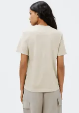 Remera color beige de corte clásico, con cuello redondo y mangas cortas.