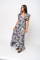 Vestido largo con estampado floral en tonos lila, verde y blanco, con escote en V, mangas cortas con volados y lazo ajustable en la cintura.