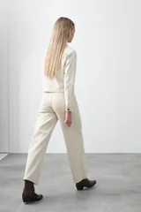 Pantalón de denim azul oscuro con corte flare, ajustado en la cadera y amplio en el ruedo. Presenta pespuntes a contratono en color blanco que resaltan las costuras.