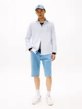 Camisa celeste de algodón Oxford, corte regular, cuello abotonado, puños redondeados con botón, logo de Tommy Jeans bordado en el pecho.