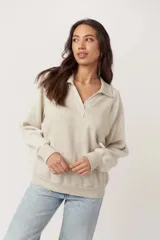 Pullover de tejido liso con mangas de fleece, cuello camisero con escote en V y puños y bajo acanalados.