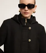 Saco gris de polivelour con capucha, cuello alto con cremallera, abotonado delantero cruzado, bolsillos delanteros y mangas largas.