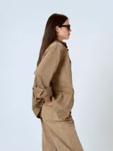 Chaqueta de denim azul oscuro con cuello de piel sintética color borgoña, cierre frontal con botones a presión, bolsillos de parche con solapa en el pecho y bolsillos laterales.