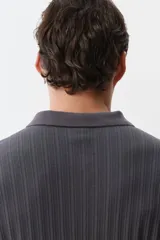 Remera polo gris de punto texturizado de peso medio, corte slim fit, manga corta, cuello clásico, tapeta de botones y bajo recto.