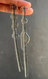 Aros largos con base de strass plateado y negro, con apliques de resina transparente.