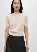 Jersey de punto fino color beige, con manga corta, cuello redondo y diseño recto.