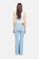 Pantalón de jean celeste con corte flare y diseño de parches en diferentes tonos de azul.