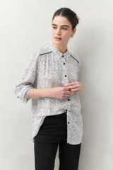 Camisa de manga larga con estampado paisley en tonos azul y blanco, cuello camisero y cierre frontal con botones.
