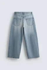 Pantalón de jeans de algodón, corte baggy fit, tiro medio, con efecto lavado en tonos grises y verdes. Presenta cinco bolsillos y cierre frontal con cremallera y botón.