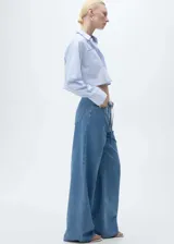 Pantalón de jean celeste de corte wideleg, con cintura elástica ajustable con cordón, cinco bolsillos y trabillas.