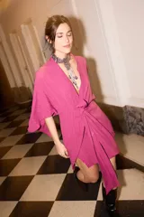 Vestido corto fucsia tipo kimono con mangas abiertas y tiras ajustables en la cintura.