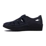 Zapato guillermina negro de cuero sintético, con punta cerrada, aberturas laterales, ajuste con velcro y suela de goma con plataforma baja.