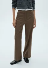Pantalón de vestir marrón con estampado de cuadros pequeños, corte wideleg, tiro medio, bolsillos laterales y cierre frontal oculto con botón, gancho y cremallera.