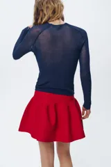 Falda mini roja de punto con cintura elástica y corte evasé.