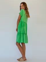 Vestido corto de algodón color naranja, con corte evasé y volados en el ruedo.