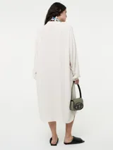 Vestido camisero de lino color tostado, con botones en la parte delantera y bolsillos ocultos.