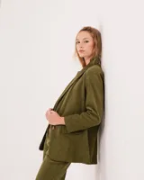 Blazer oversized de pana color verde militar, con cierre delantero de dos botones y hombreras finitas.
