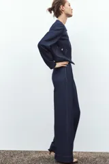 Pantalón de tiro alto color azul denim, con pinzas delanteras, bolsillos frontales, pernera ancha y pespuntes combinados a contraste en color beige.