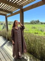 Vestido camisero amplio y largo de lino color azul, con botones de nácar, cuello camisero y bolsillos laterales.