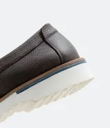Zapato slip on marrón de cuero con suela blanca.