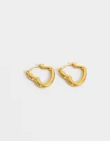 Aros tipo argolla con forma de corazón, hechos de acero quirúrgico color dorado.