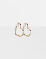 Aros dorados tipo argolla con forma de corazón y pequeños strass incrustados.