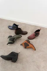 Botas Chelsea de cuero color marrón oscuro, con paneles laterales elásticos en marrón y suela de goma.