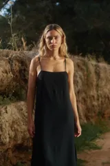 Vestido midi negro de lino y rayón con tiras finas ajustables, escote recto y tajo lateral.