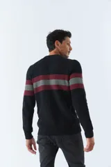 Sweater de punto negro con cuello redondo y mangas largas. Presenta dos franjas horizontales en el pecho, una color borgoña y otra gris.