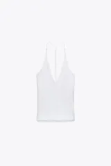 Top blanco de cuello halter con escote pico y tiras finas cruzadas en la espalda.