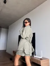 Blazer verde con rayas verticales blancas, de corte holgado, con cuello clásico, cierre frontal con botones y mangas largas.