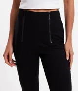 Pantalón skinny de bengalina negra, corte sastrero, tiro alto y cierre track frontal.