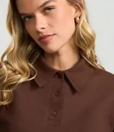 Suéter de manga larga color crema, confeccionado en algodón y poliéster, con cuello polo y tapeta de botones.