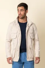 Campera color beige de nylon con cuello alto, cierre frontal con cremallera y bolsillos tipo safari con solapa y botón.