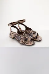 Sandalias bajas color marrón con estampado de piel de serpiente, tira delantera con detalle de hebillas y tira trasera con hebilla metálica.