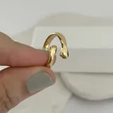 Anillo dorado con diseño de manos abrazándose.