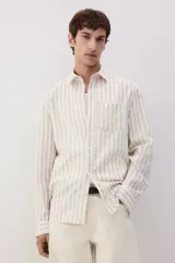 Camisa de manga larga con cuello inglés y bolsillo en el pecho. Diseño a rayas verticales en tonos beige y blanco. Corte estándar.
