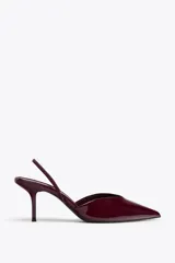 Zapato destalonado color borgoña, con efecto acharolado, escote en pico, cierre con tira trasera ajustable, tacón fino y acabado en punta.