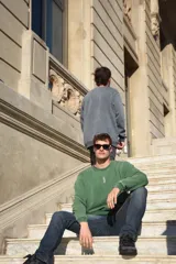 Buzo verde con cuello redondo y logo pequeño bordado en el pecho.