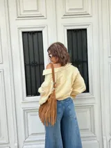 Camisa a rayas verticales amarillas y blancas, de corte holgado y mangas largas.