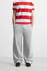 Pantalón jogger negro de corte ancho, confeccionado en tejido de algodón con interior de rizo. Cuenta con cintura elástica ajustable con cordón interior, bolsillos laterales y bolsillo trasero de parche.