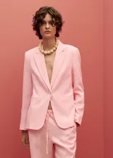 Chaqueta de lino color celeste con cuello de pico y solapas con muesca, cierre frontal con botón, manga larga con puños abotonados, diseño recto, dos bolsillos de ribete en la parte delantera y abertura posterior en el bajo.
