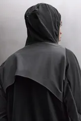 Chaqueta deportiva negra con paneles grises en hombros y laterales, capucha ajustable, cierre frontal con cremallera, bolsillos laterales con cremallera y puños elásticos. Zara Athleticz.