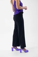 Pantalón negro de corte palazzo con lazo en la cintura.