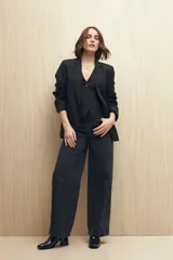 Pantalón de jean negro de corte ancho, tiro medio y cinco bolsillos.