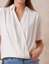 Blusa color blanco de lino, con cuello con solapa y escote en V. Delantera cruzada y mangas cortas. Marca Cable & Gauge.